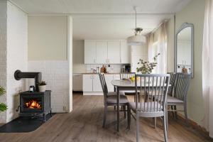 a kitchen and dining room with a table and a fireplace at Basecamp Dramsvegen Aurora Viewpoint in Tromsø