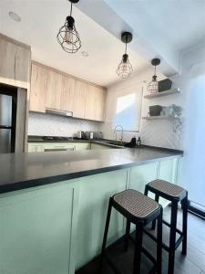 a kitchen with two stools and a counter in a kitchen at Casa Nidos in Santiago +3 photos