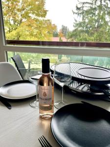 a table with a bottle of alcohol and glasses on it at Studio cosy à Métabief in Métabief +8 photos