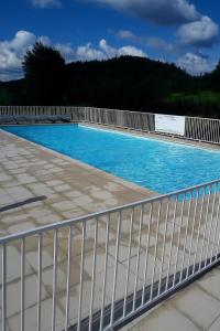 a swimming pool with a white fence around it at Studio cosy à Métabief in Métabief