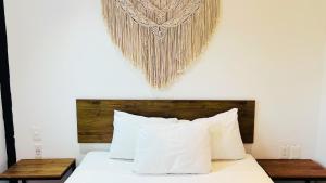 ein Schlafzimmer mit einem Bett mit hölzernem Kopfteil in der Unterkunft Live Coco Suites - Hotel Boutique & Rooftop in Playa del Carmen + 44 Fotos