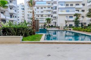 una piscina frente a un edificio de apartamentos en Ocean Park Sunset Escape beach front with swimming pool, en Aïn Harrouda