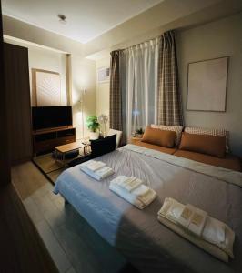 a bedroom with a bed with two towels on it at Maple Grove Yasuragi Stay in General Trias +31 photos