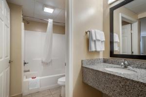 ein Badezimmer mit Waschbecken, Toilette und Spiegel in der Unterkunft SureStay Studio by Best Western Gonzales in Gonzales + 7 Fotos