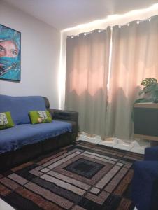 ein Wohnzimmer mit einer Couch und einem Fenster in der Unterkunft Apartamento Rainha Turquesa in Dourados