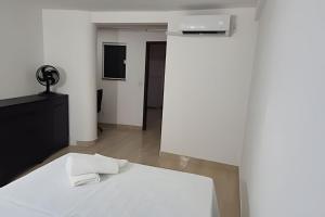 a bedroom with a white bed and a white wall at Apartamento brisa do oceano in Natal +30 photos