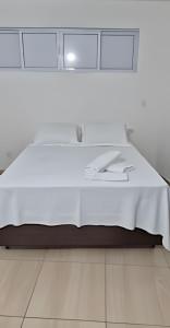 a white bed with white sheets on top of it at Apartamento brisa do oceano in Natal