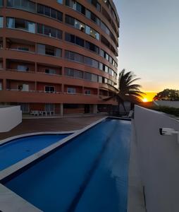 a swimming pool in front of a building at Apartamento brisa do oceano in Natal