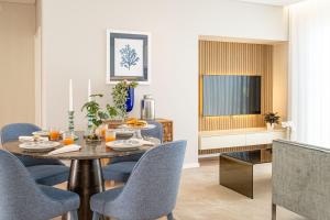 a dining room with a table and chairs and a television at Casa Graminho in Ponta do Sol