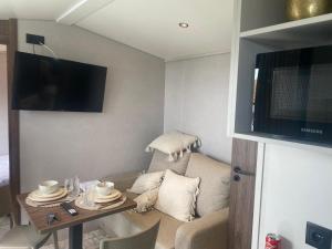 a small living room with a table and a television at Chalet Tiny & Campagne in Onnion