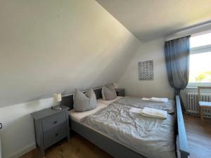 a bedroom with a bed with white sheets and a window at Doppelzimmer-Nigehoern in Baltrum