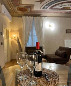 a bottle of wine sitting on a table with two wine glasses at FresCo b&b in Sarnico