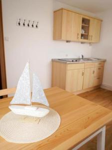 a wooden table with a paper boat on top of it at Ferienwohnung-Memmert in Baltrum