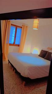 a bedroom with a large bed in a room with windows at Maison Pivoines in Saint-Martin-dʼArdèche
