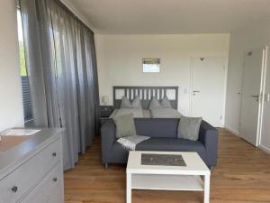 a living room with a blue couch and a table at Ferienwohnung-Neuwerk in Baltrum