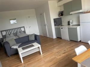 a living room with a couch and a table and a kitchen at Ferienwohnung-Neuwerk in Baltrum