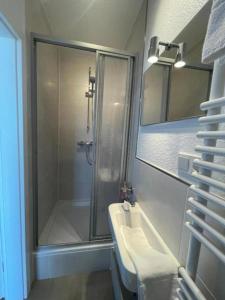 a bathroom with a shower and a sink and a mirror at Ferienwohnung-Neuwerk in Baltrum