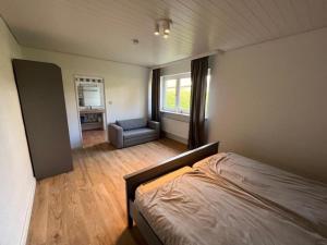 a bedroom with a bed and a chair in it at Ferienwohnung-Helgoland in Baltrum