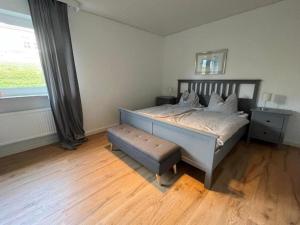 a bedroom with a bed with a bench and a window at Ferienwohnung-Helgoland in Baltrum