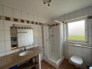 a bathroom with a sink and a shower and a toilet at Ferienwohnung-Helgoland in Baltrum