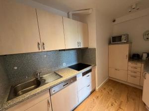 a kitchen with white cabinets and a sink and a refrigerator at Ferienwohnung-Helgoland in Baltrum