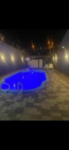 a large blue swimming pool at night with lights at Espaço Clarabella in Serra Negra +8 photos