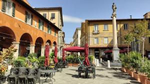 an outdoor patio with tables and chairs and umbrellas at L'ANGOLO di GALILEO in Pisa