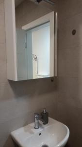 um banheiro com pia branca e espelho em Apartman studio KOPS em Vranješ