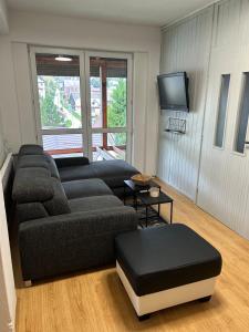 un salon avec un canapé et une télévision dans l'établissement Apartmán Malatiná, à Malatiná