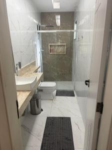 a bathroom with a shower and a toilet and a sink at Casa de 4 Quartos - 2 suites in Ananindeua +2 photos