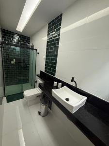 a bathroom with a sink and a shower and a toilet at Casa de 4 Quartos - 2 suites in Ananindeua