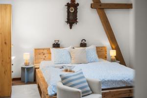 a bedroom with a bed and a chair and a clock at Statek Luigi in Tuchlovice +40 photos