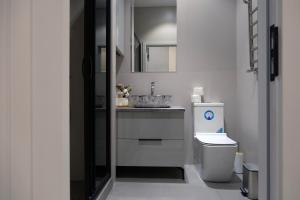 ein weißes Badezimmer mit Waschbecken und Toilette in der Unterkunft Tashkent City Downtown Deluxe Host Apartments in Taschkent + 27 Fotos