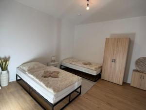 a room with two beds and a wooden cabinet at FlexHome Stadtnatur Ferienwohnung in Lippstadt