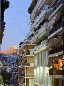 a building with balconies and plants on the side of it at Acropolis Path - Elegant Apartment near Plaka in Athens