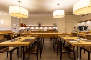 a dining room with wooden tables and chairs at HSM Hotel San Martino in Garbagnate Monastero 