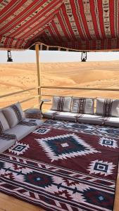 a bed under a tent in the desert at Desert Vibes Camp in Bidiyah