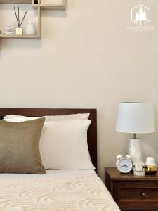 a bedroom with a bed with a clock on a night stand at Solace - 1BR Brenthill Condo with Balcony Near Session and SM in Baguio