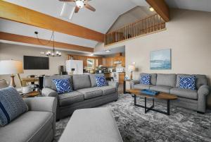 a living room with two couches and a table at Beach Front Houghton Lake with Game Room in Port Huron