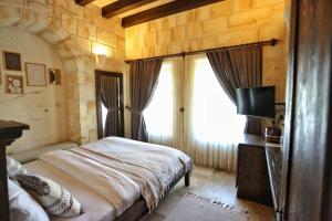 a bedroom with a large bed and a window at Nujel'm Cappadocia in Ürgüp