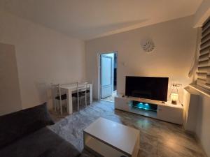 a living room with a couch and a tv and a table at Stan na dan Apartman in Bor
