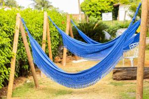 a blue hammock on posts in a garden at Pousada Dois Irmãos in Fernando de Noronha