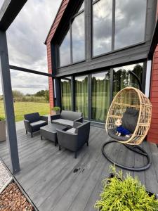 a porch with a chair and a swing at Agroturystyka Rajska Jabłoń in Maków