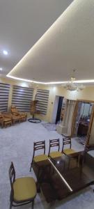 a room with chairs and a table and a stage at Rashid aka Goest house in G‘azalkent