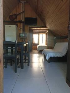 a room with two beds and a table and a desk at Pukará Reservas con depósito in Barra del Chuy