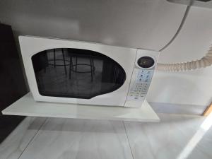 a microwave oven with two chairs inside of it at Flat completo a 17 minutos do campo do Goiás in Aparecida de Goiania
