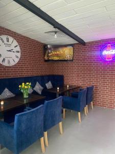 a restaurant with tables and chairs and a clock on the wall at KING Guest Inn in Drawsko Pomorskie