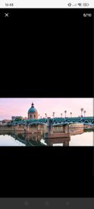 un pont sur une rivière avec un bâtiment et un pont dans l'établissement location Indépendante 28m2, à Toulouse 2 autres photos