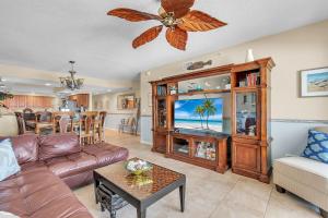 a living room with a couch and a tv at La Vistana #A503 in St Pete Beach