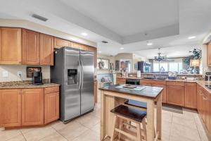 a kitchen with a stainless steel refrigerator and wooden cabinets at La Vistana #A503 in St Pete Beach